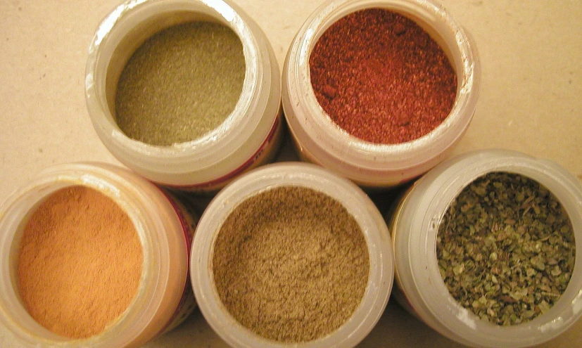 four jars containing different spices in them