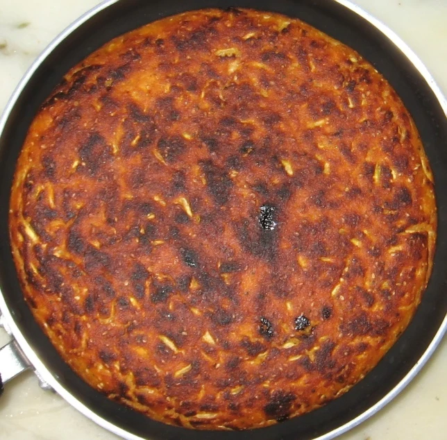a closeup of a small, dirty, rusty looking pizza