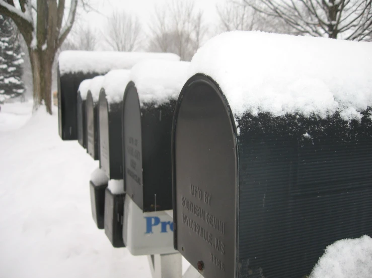 four mailboxs sit in the snow covered ground