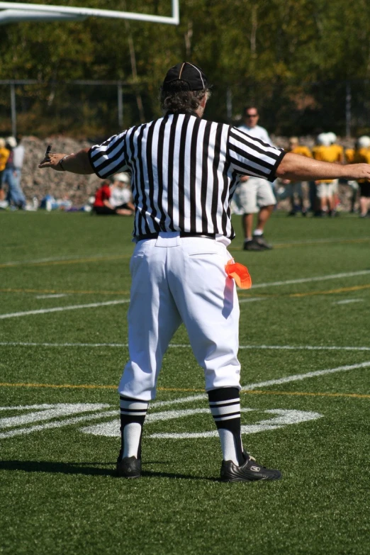 a referee is holding his hands out to the sideline