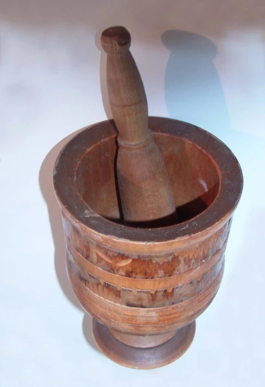 the wooden mortar and mortar is placed inside a small cup