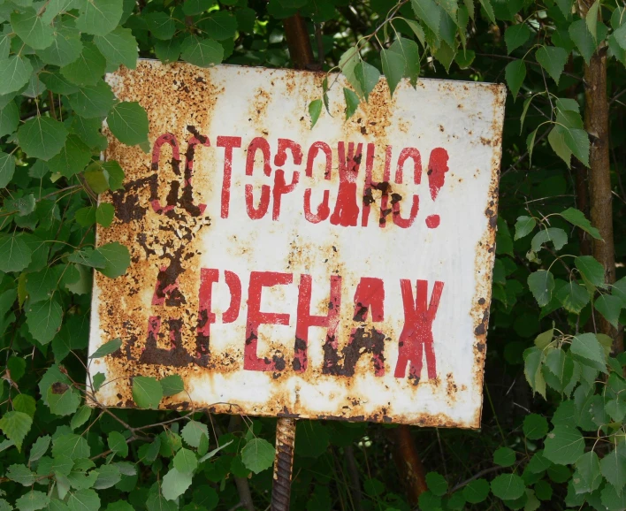 an old sign advertising the area to stop to gasoline
