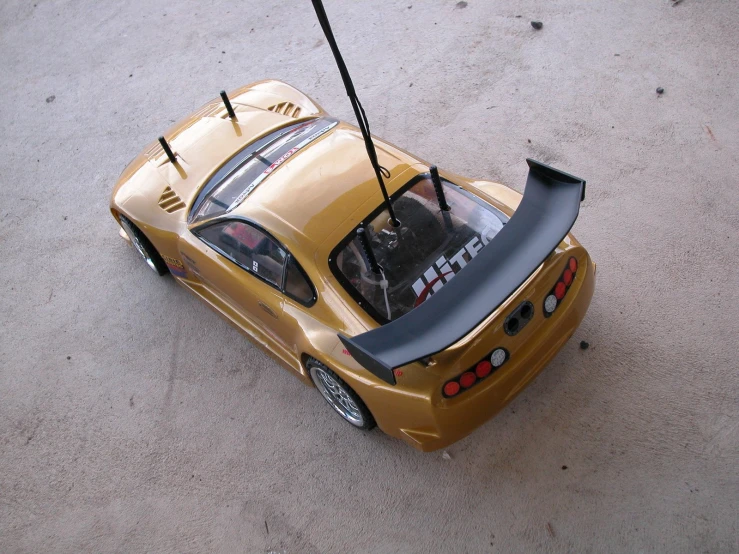 the back end of a yellow car, with the hood up