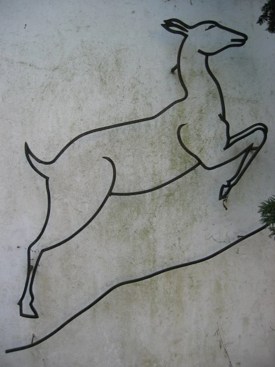 a drawing on the side of a building with an outline of a deer running