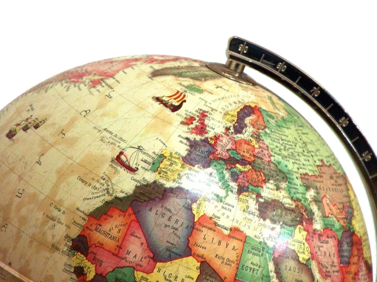 an antique world globe sits on a desk