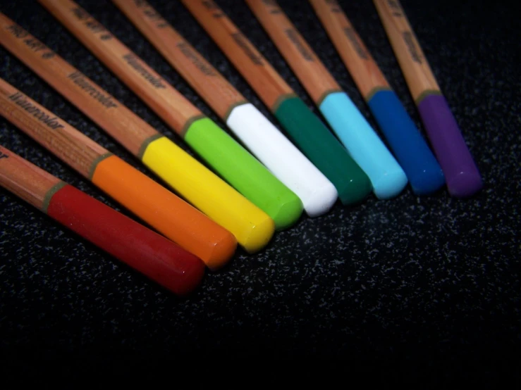 the multi - colored handles of different colored pencils are shown
