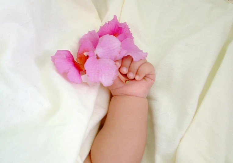 a small baby is laying in bed with flowers on it