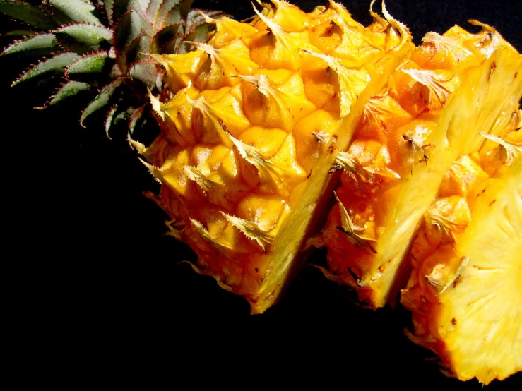 two pieces of pineapple are displayed against a dark background