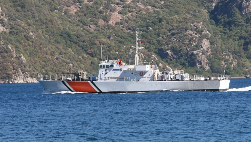 a small gray and red boat coming in for a landing