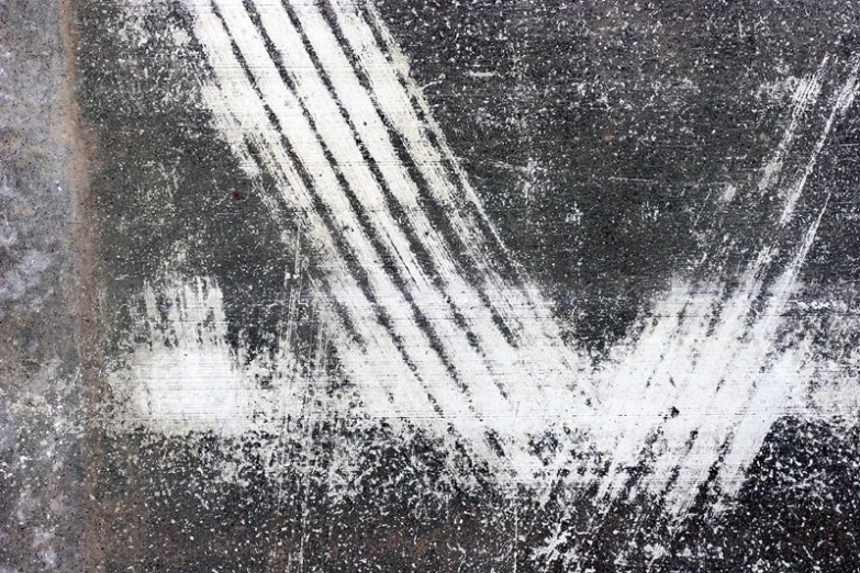 a grungy image with white paint on a gray wall