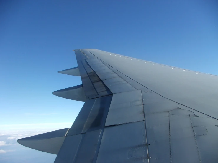 a wing of an airplane in the blue sky