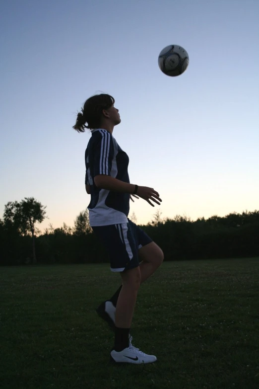 a young woman on a field about to kick a soccer ball