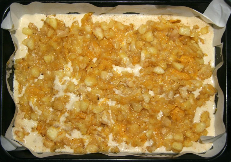 a pan of food is covered with fruit and cheese