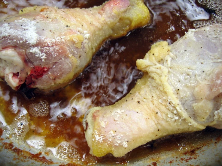 a close up of two pork chops in brown sauce