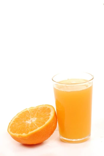 there is a glass of juice and an orange