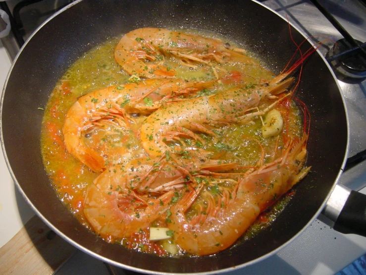 cooked shrimp being simmers in pan on stove