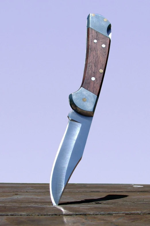 a wooden handle knife that is about to hit the ground