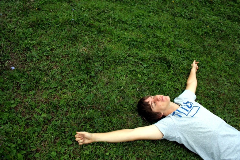 boy laying on the grass playing with a frisbee