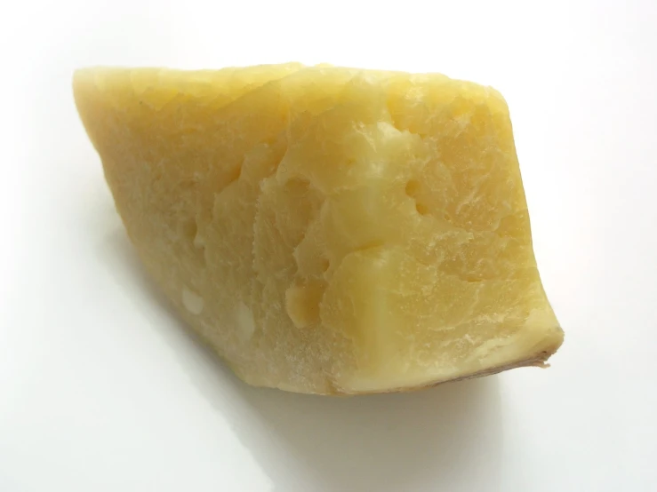 a piece of cheese is on a white surface