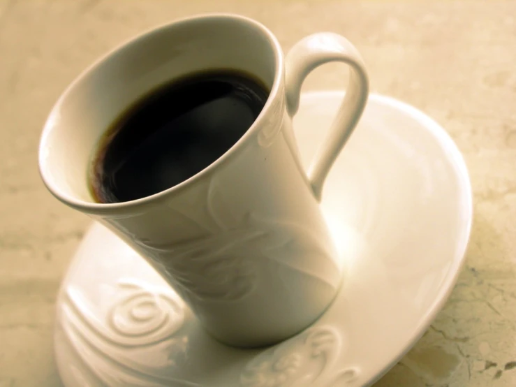 an almost empty coffee cup sitting on top of a white plate