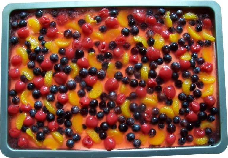 berries and oranges are on the pan for this dessert