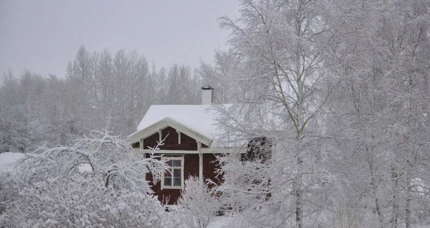 a small house in the middle of winter with snow on it