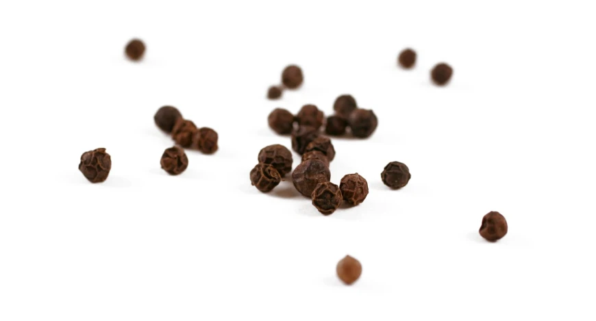 some cocoa seeds have been tossed on a white surface