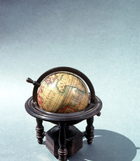 a small globe sitting on a wooden stand