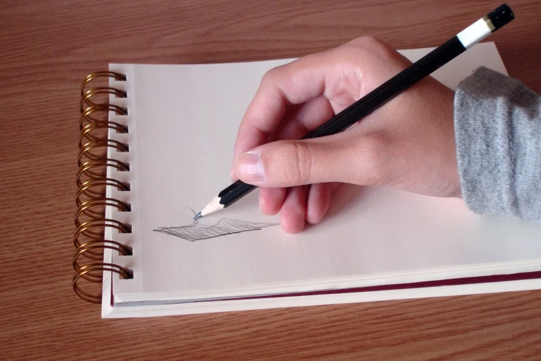a person's hand is drawing a line with a pencil