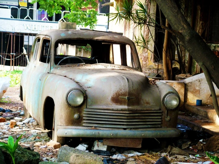 old, rusty car with no hood on and broken down exterior