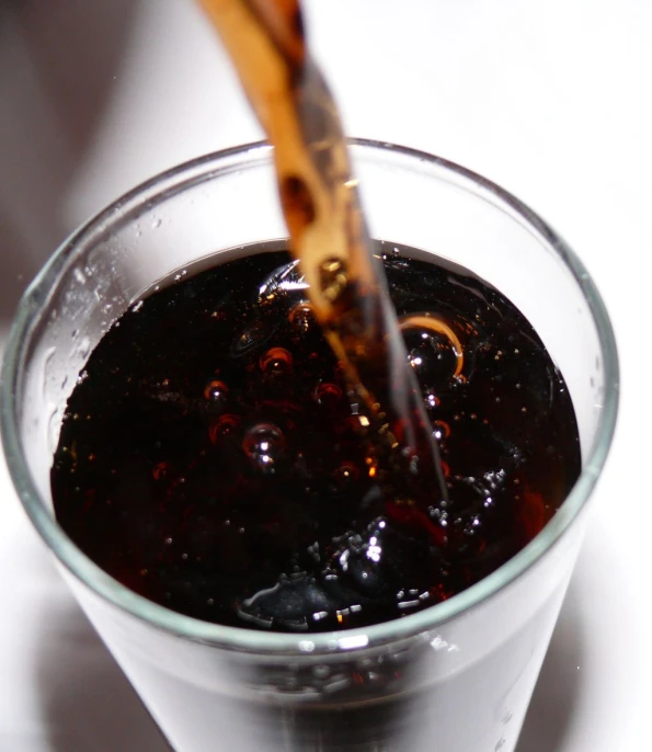 a plastic cup full of liquid is being poured into the glass