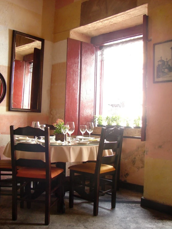 a restaurant table and chairs with a clock on the wall