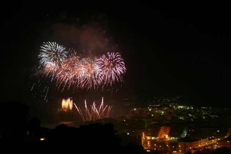 fireworks on the water and a city in the background