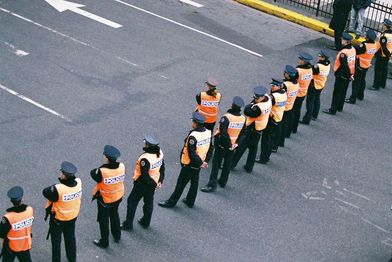 a line of police stand behind a road