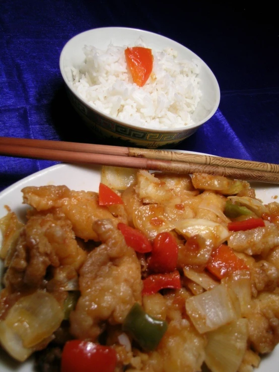 an oriental dish on a white plate with chopsticks