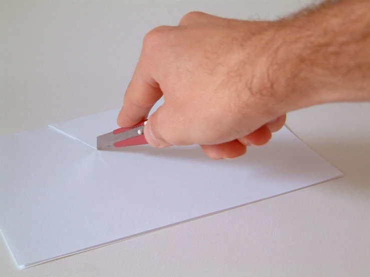 a close up of a person  paper with a sharp knife