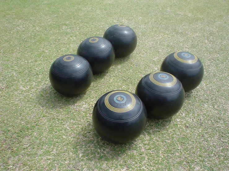 five exercise balls are on the grass, ready to be used