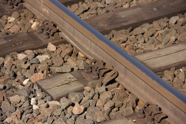 an old rail road track with rocks and some wood