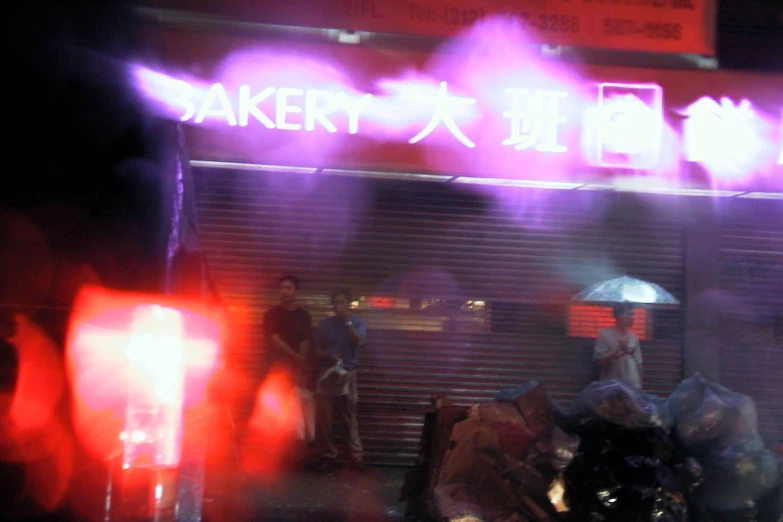 the neon lights of people standing outside of a theatre