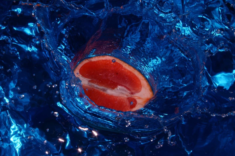 the  orange is floating in some blue water