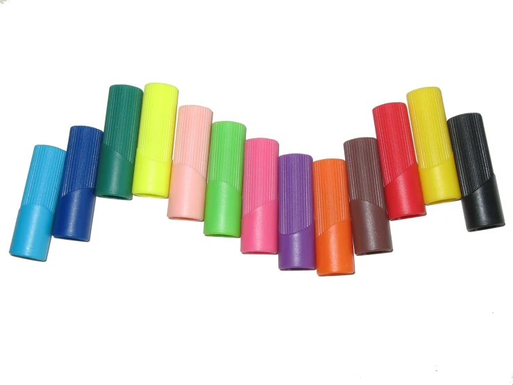 there are some small colored plastic tubes on a white background
