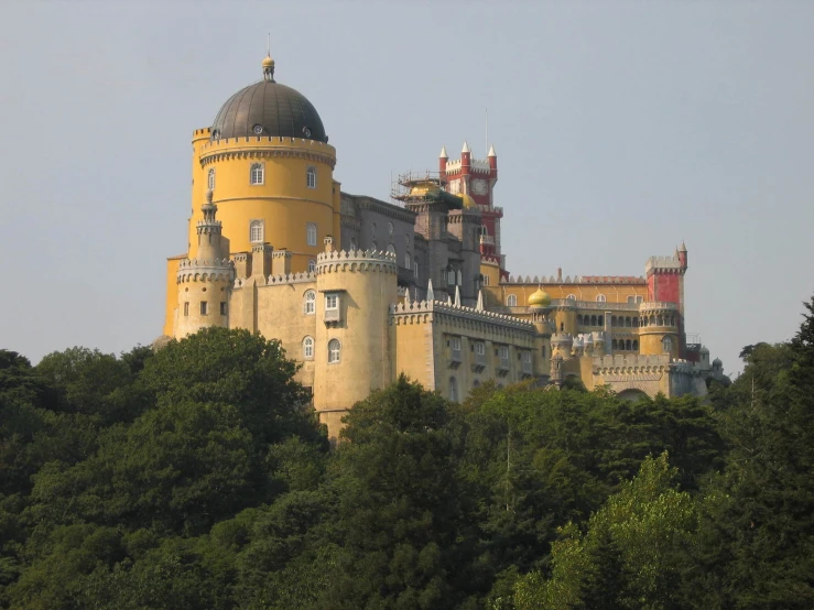 a large yellow castle on top of a hill