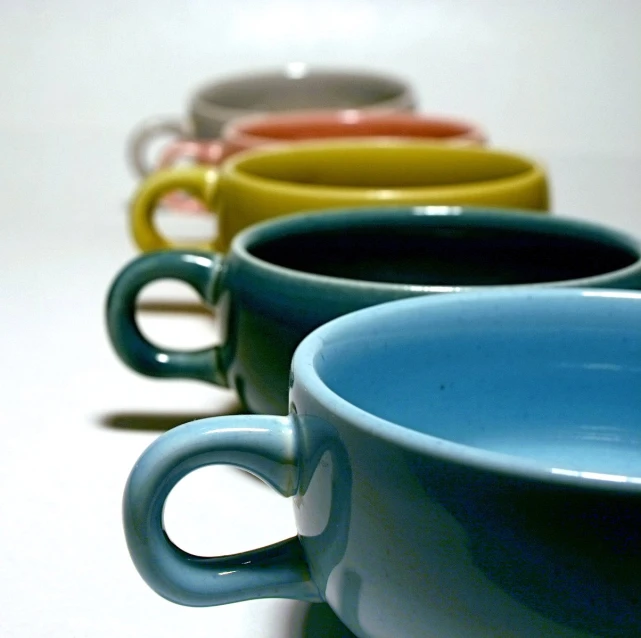 four mugs lined up together on a table