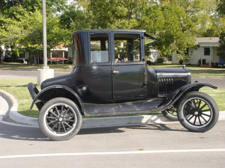an antique black car parked in the street