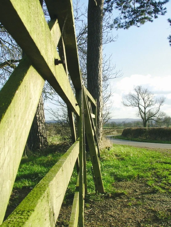 a wooden fence that stretches out onto a grassy field