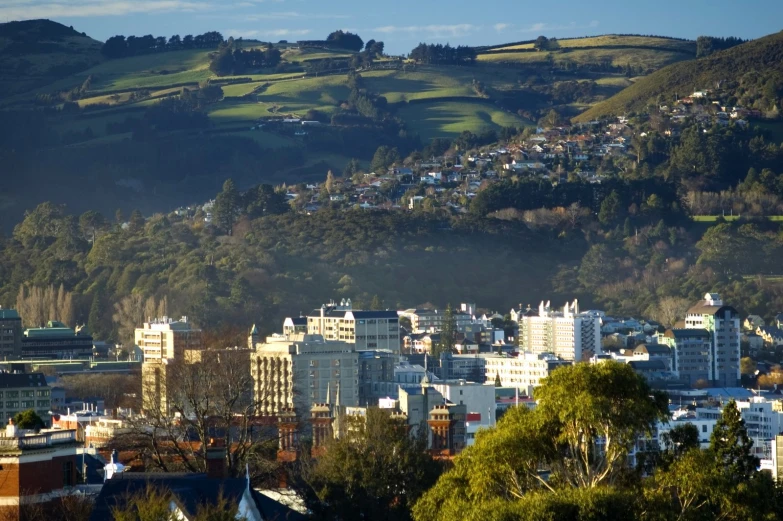 a picture of some green hills and a city