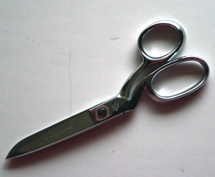 a pair of scissors on a light pink table