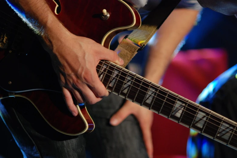 hands holding a guitar in front of an audience
