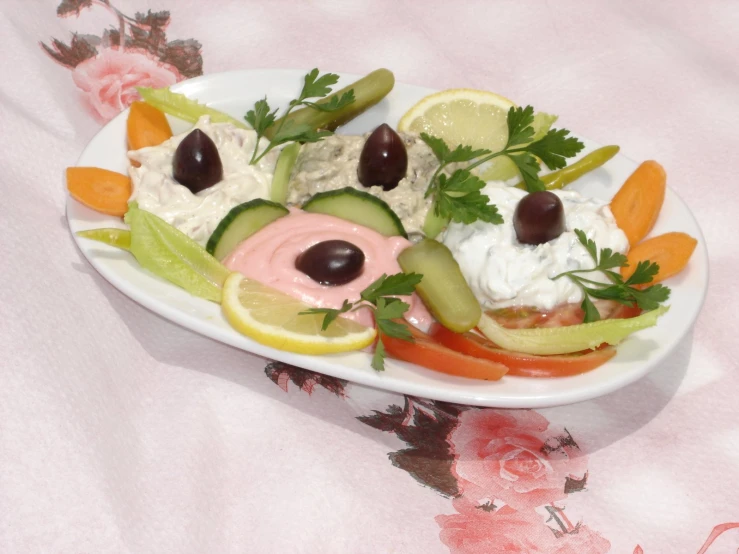 a plate with cucumbers, carrots and dips on it