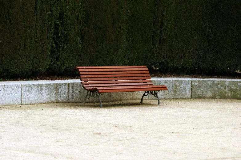 a wooden bench with an iron frame on top of a concrete slab